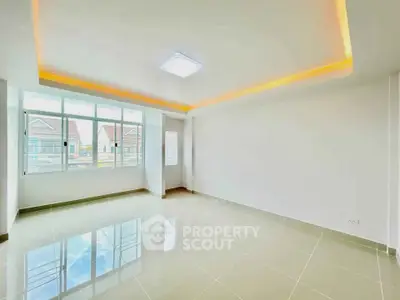 Spacious and bright living room with modern ceiling lights and large windows.