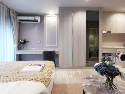 Modern bedroom with cozy decor, featuring a stylish bed, built-in wardrobe, and a compact kitchen area.