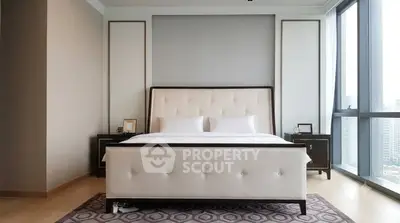 Luxurious bedroom with modern decor and large windows offering city views