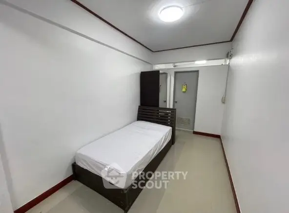 Minimalist bedroom with single bed and white walls in compact space