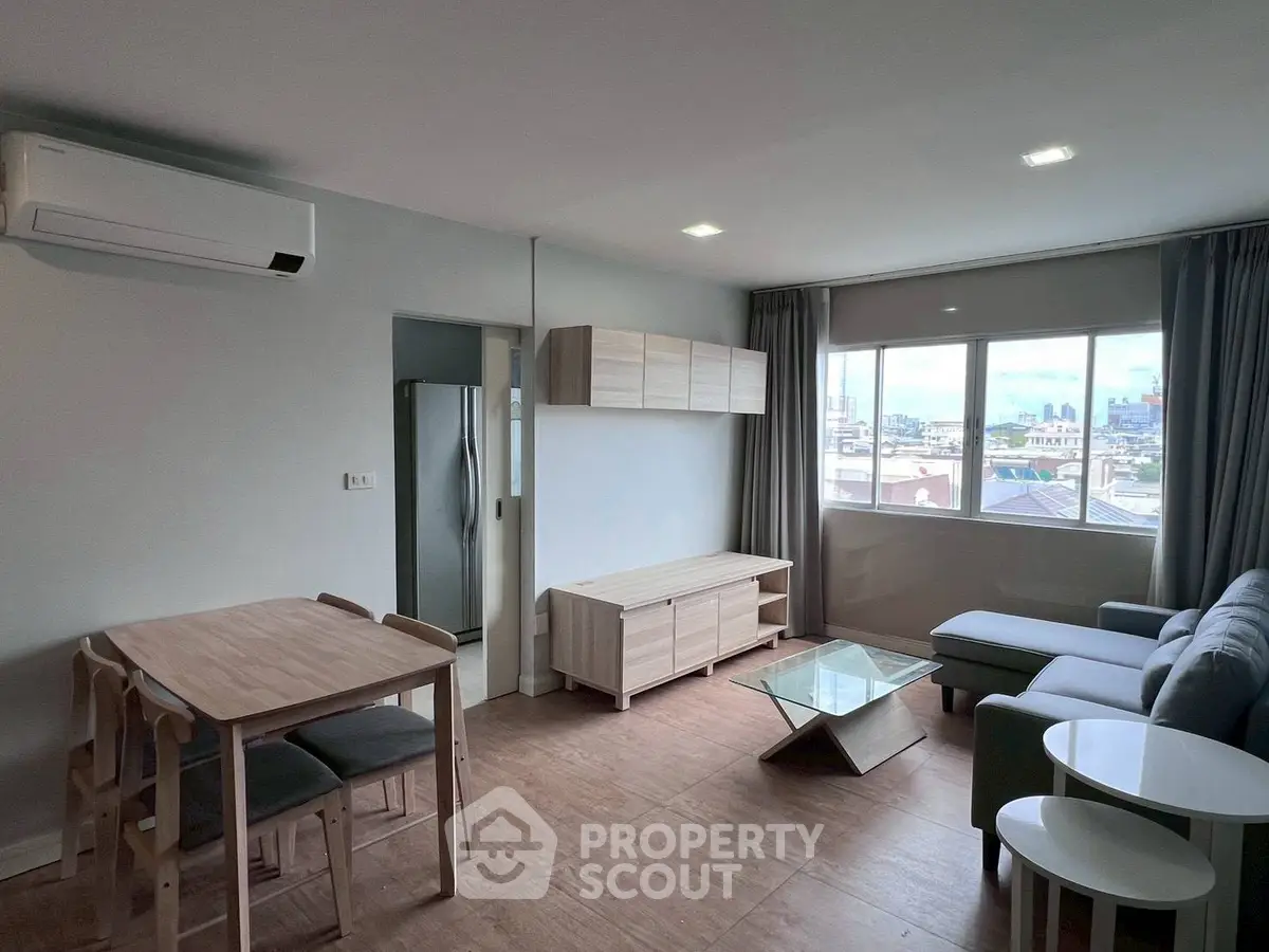 Modern living room with city view, featuring sleek furniture and natural light.