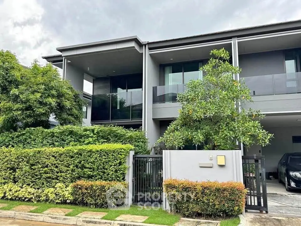 Modern two-story house with lush greenery and sleek design, perfect for contemporary living.