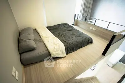 Modern loft-style bedroom with minimalist design and wooden flooring.