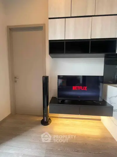 Modern living room with sleek TV setup and stylish shelving, perfect for entertainment enthusiasts.