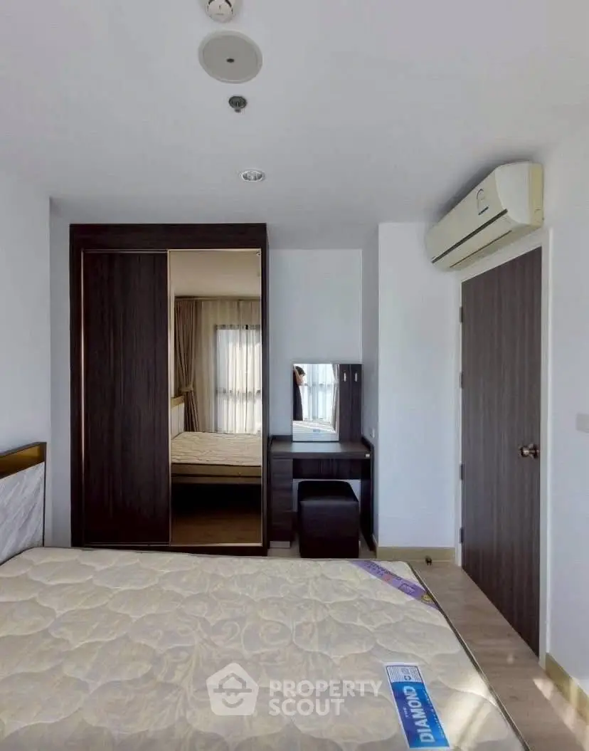 Modern bedroom with mirrored wardrobe and air conditioning in a stylish apartment.