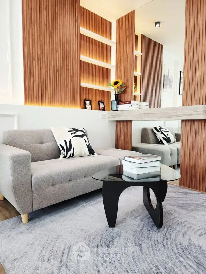 Modern living room with stylish sofa, wooden paneling, and decorative lighting