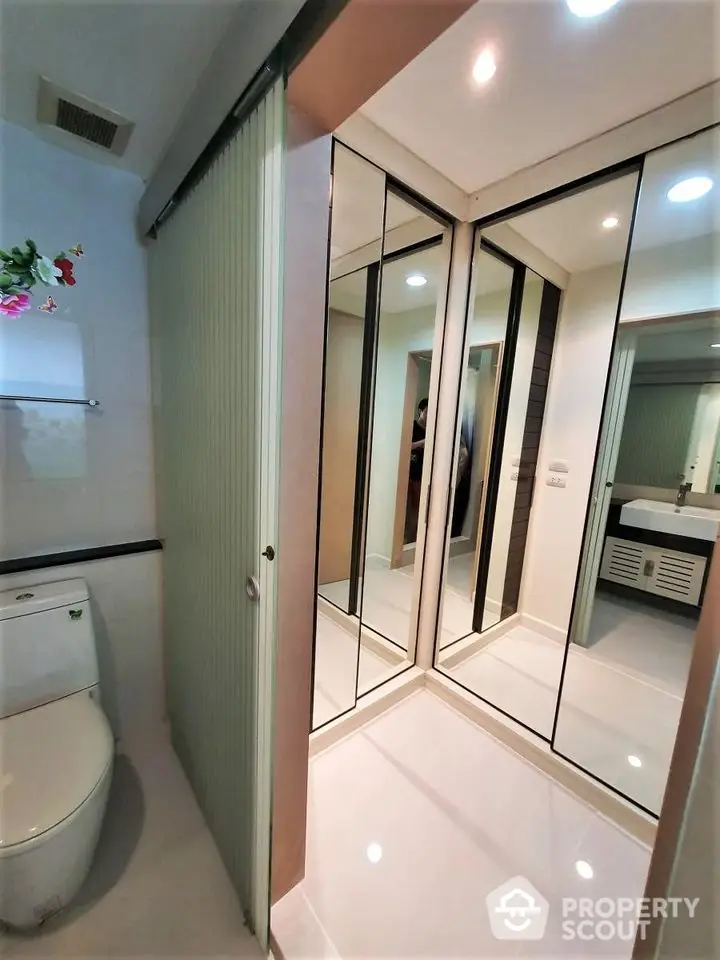 Modern bathroom with mirrored closet and sleek fixtures