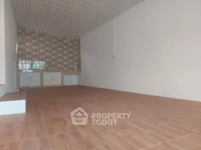 Spacious empty room with tiled floor and patterned wall, ideal for customization.