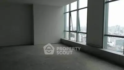 Spacious empty room with large windows offering stunning city views