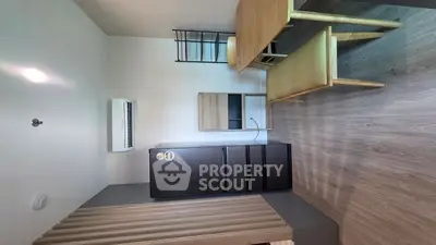 Modern kitchen with sleek black fridge and wooden dining set in a cozy apartment.