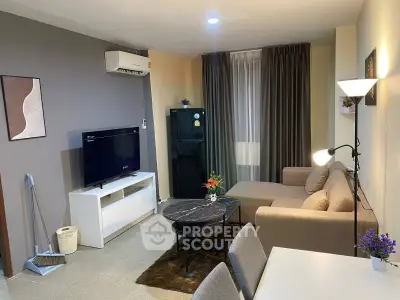 Modern living room with stylish decor, featuring a cozy sofa, flat-screen TV, and elegant lighting.