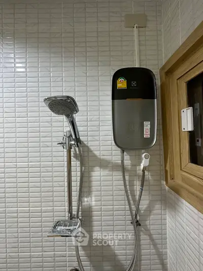 Modern bathroom with sleek shower and water heater in tiled interior