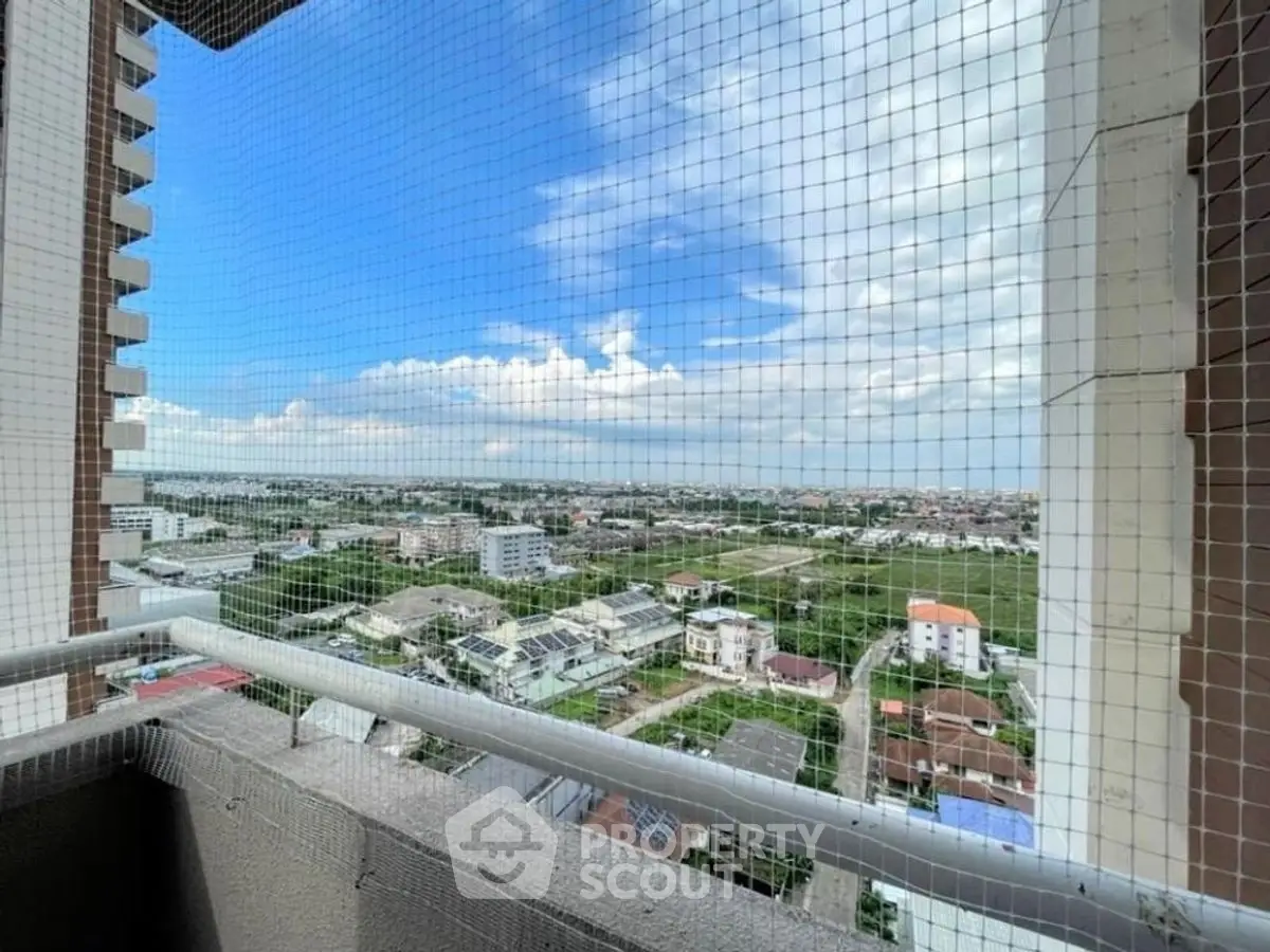 Stunning high-rise balcony view with expansive cityscape and blue sky.