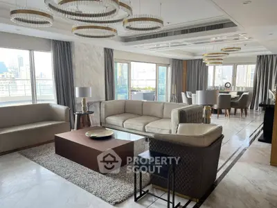 Luxurious living room with elegant decor and city view, featuring plush sofas and modern lighting.