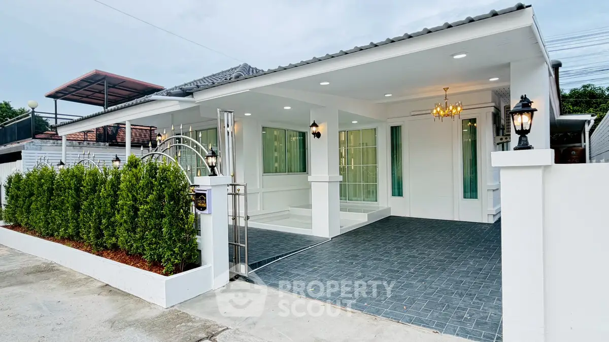 Charming modern white house with elegant exterior lighting and lush greenery, perfect for family living.
