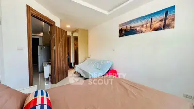 Cozy bedroom with modern decor and a glimpse of the kitchen area, perfect for urban living.