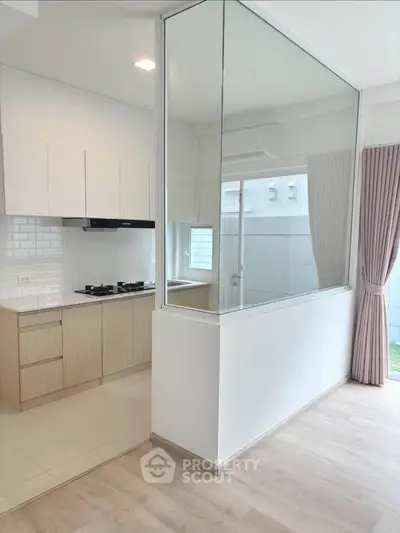 Modern kitchen with gas stove and open layout, featuring sleek cabinetry and bright natural lighting.