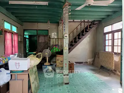 Spacious living area with vintage decor and wooden staircase in a classic home