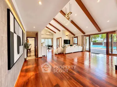 Spacious modern living room with wooden floors and pool view, perfect for luxury living.