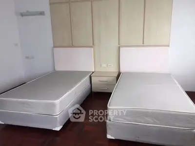 Spacious bedroom with twin beds and elegant wooden flooring