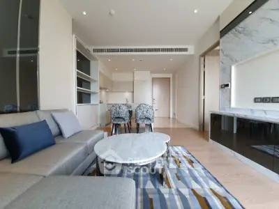 Modern open-plan living room with stylish furniture and kitchen in a luxury apartment.