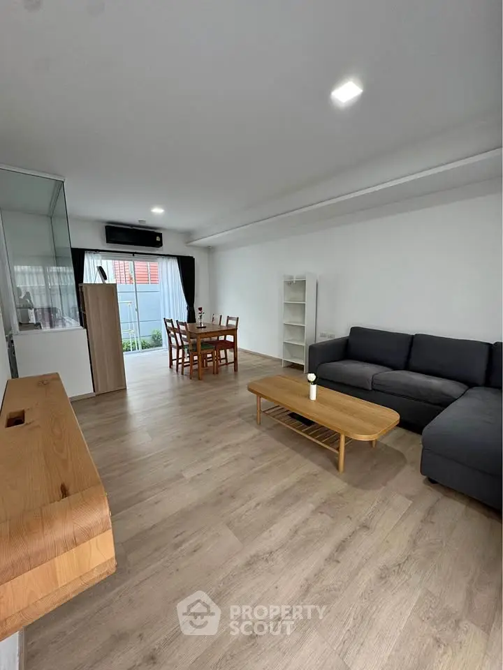Spacious modern living room with wooden flooring and stylish furniture, perfect for relaxation and entertainment.