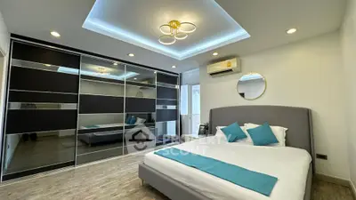 Spacious modern bedroom with stylish lighting and large mirrored wardrobe