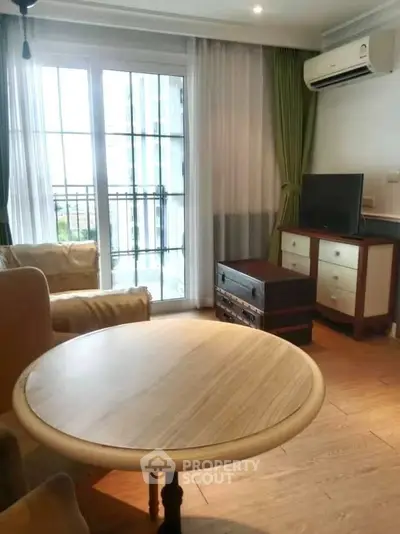 Charming living room with natural light, cozy seating, and elegant decor in a modern apartment.