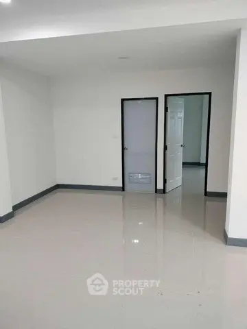 Spacious empty room with glossy tiled floor and white walls, ideal for customization.