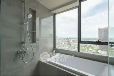 Luxurious bathroom with city view and modern bathtub in high-rise apartment.