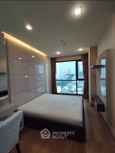Modern bedroom with city view, featuring sleek design and natural light.