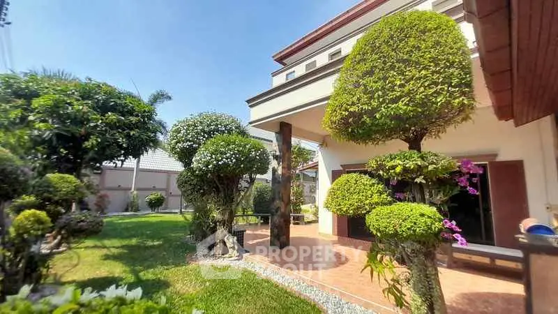 Charming garden view of a modern home with lush greenery and manicured trees.