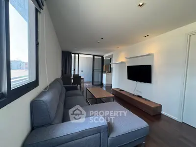 Modern living room with sleek furniture and large windows in a stylish apartment.
