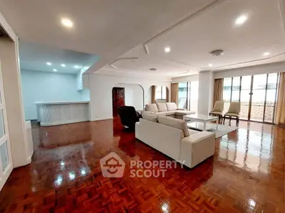 Spacious living room with elegant wooden flooring and modern furniture in a luxurious apartment.