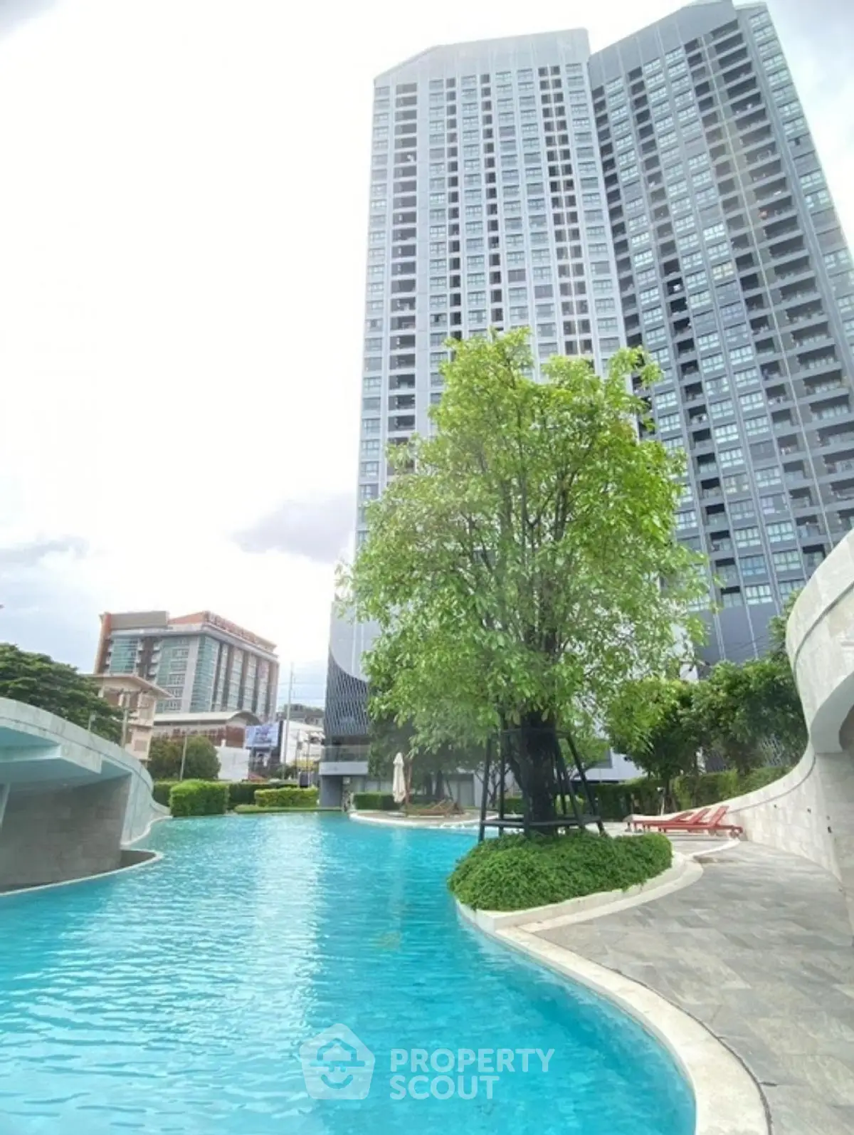 Luxurious high-rise building with stunning pool and lush greenery
