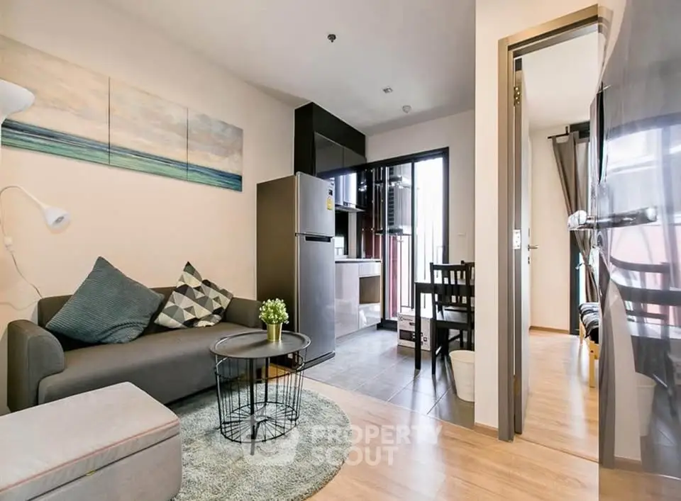 Modern living room with stylish decor and open layout, featuring a cozy sofa and dining area.