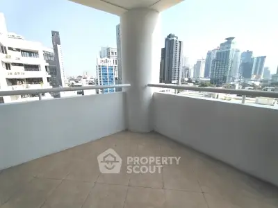 Spacious balcony with stunning city skyline views in modern high-rise building.