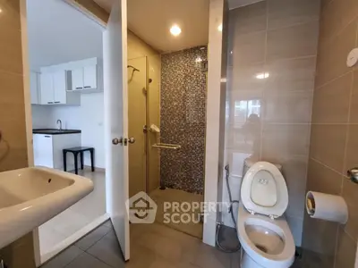 Modern bathroom with glass shower and sleek fixtures in contemporary apartment.