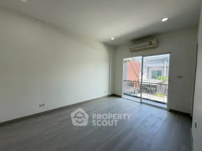 Spacious empty room with large window and balcony access, perfect for customization.