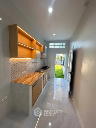 Modern kitchen with sleek design and open layout, featuring wooden cabinets and stylish backsplash.