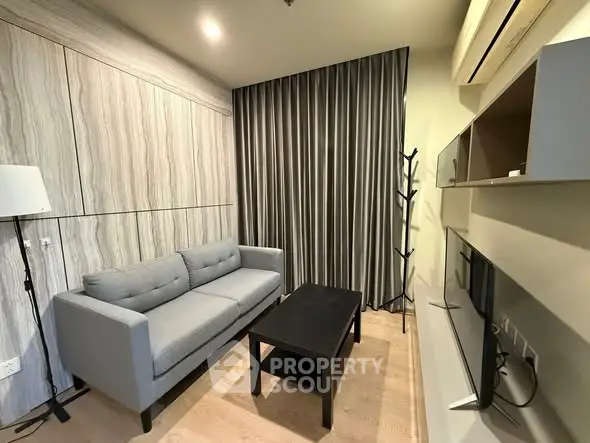 Modern living room with gray sofa, sleek TV unit, and stylish decor