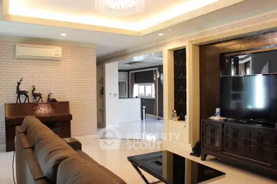 Luxurious living room with elegant decor and modern amenities, featuring a stylish TV setup and cozy seating area.