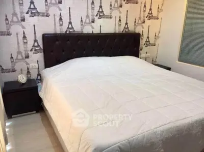 Cozy bedroom with elegant decor and Eiffel Tower wallpaper, perfect for relaxation.