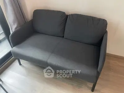 Modern gray sofa in a stylish living room with wooden flooring.