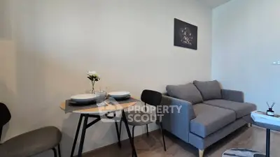 Cozy living room with modern gray sofa and dining area