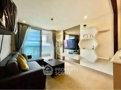 Modern living room with ocean view, stylish decor, and large TV, perfect for relaxation.