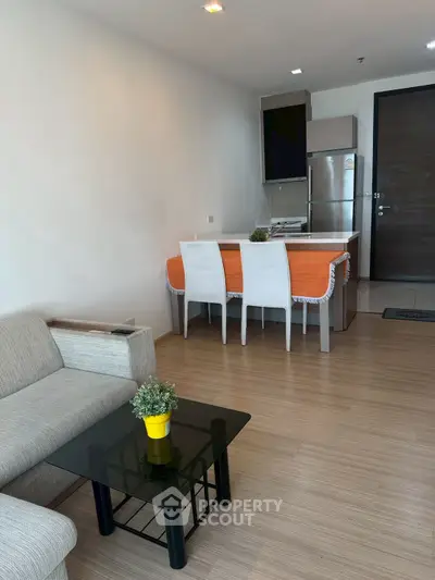 Modern open-plan living room with kitchen, featuring sleek furniture and stylish decor.