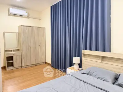 Spacious bedroom with modern furnishings and elegant blue curtains