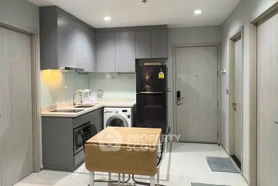 Modern kitchen with sleek cabinetry, integrated appliances, and compact dining area in a stylish apartment.