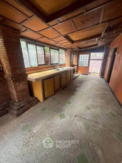 Spacious rustic kitchen with brick accents and large windows
